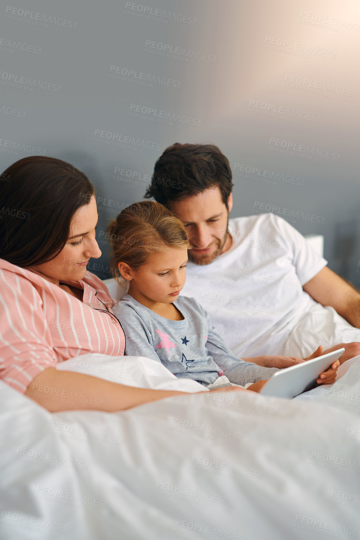 Buy stock photo Parents, tablet and girl in home for relax, bonding and playing fun games together in bed with app. Family, daughter and technology in apartment for streaming film, online or cartoon with development