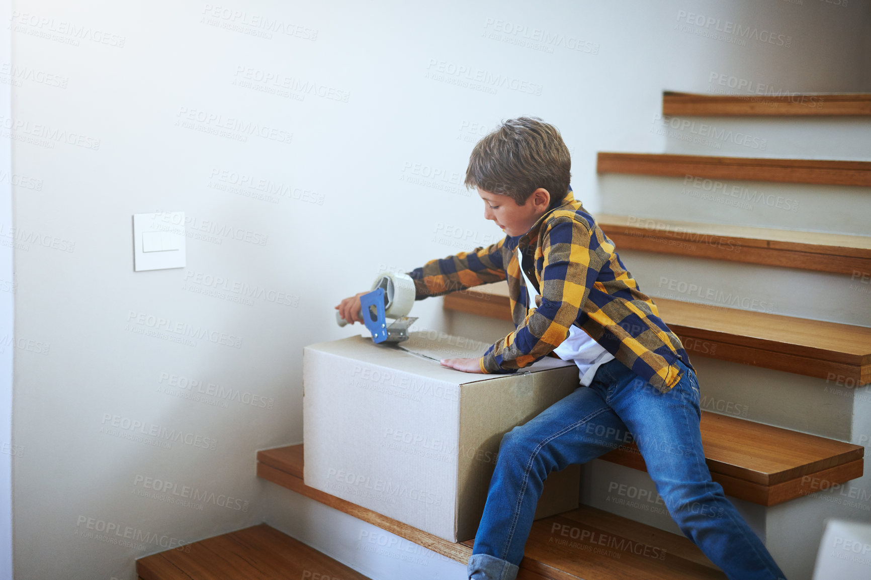 Buy stock photo Packing, moving and kid with tape for boxes on stairs for new start, real estate or property investment. Change, male child and boy with cardboard for relocation, helping or seal on package in home