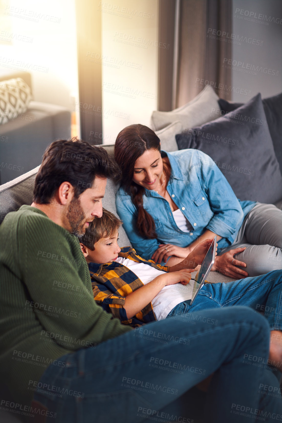 Buy stock photo Parents, boy child and tablet on sofa in house for educational games, watching cartoon and bonding. Relax, people and family with digital app on couch for online video, streaming service and learning