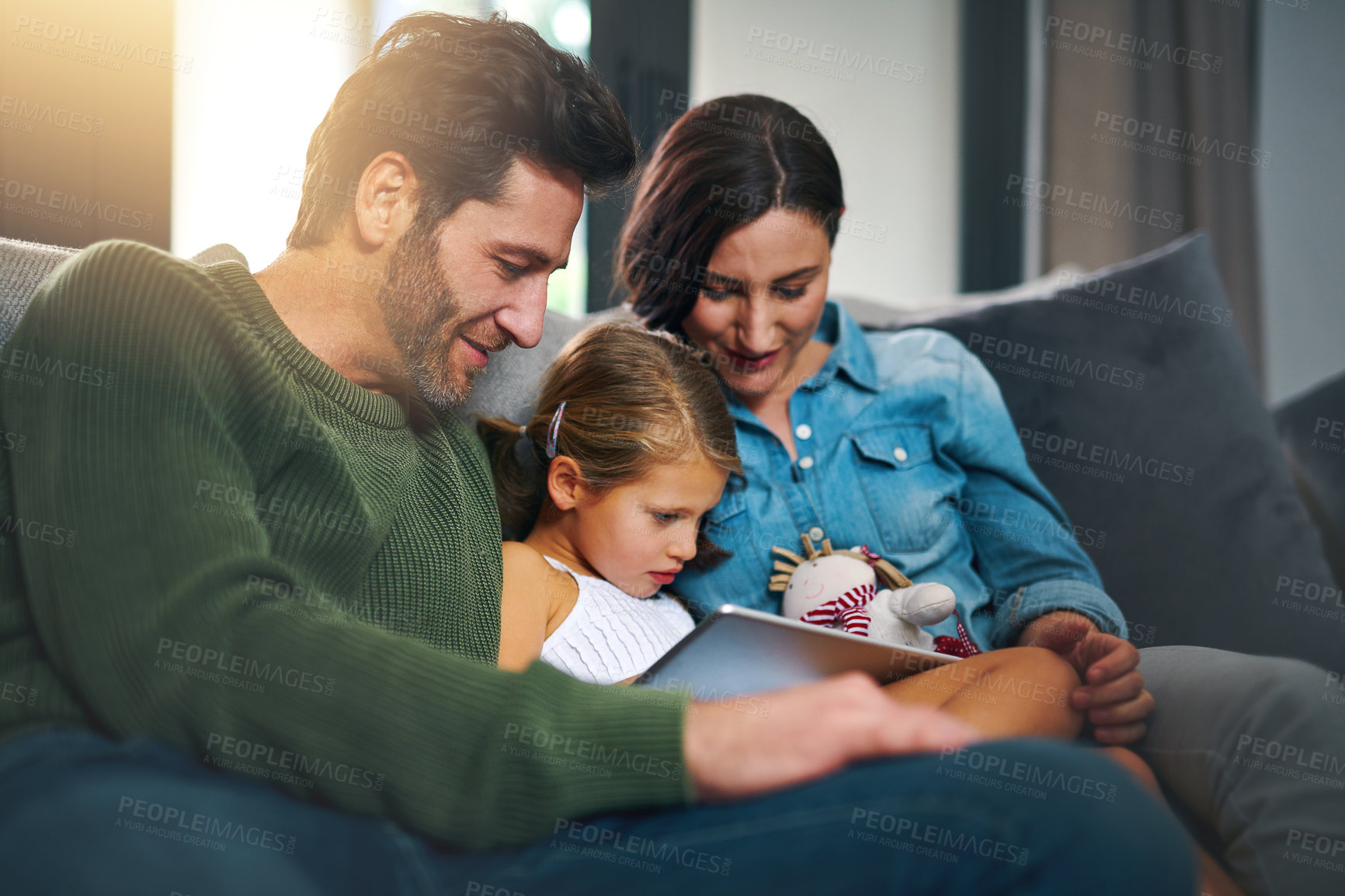 Buy stock photo Tablet, rest and child with parents on sofa in home streaming movie, show or series online. Bonding, digital technology and girl kid with mother and father in living room playing game at house.