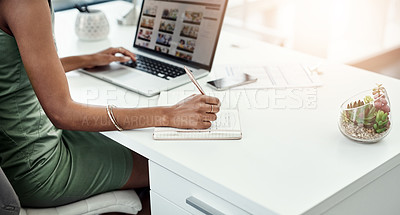 Buy stock photo Cropped shot of an unrecognizable young businesswoman writing in her diary while working in the office