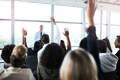 Buy stock photo Shot of a group of businesspeople raising their hands during a presentation