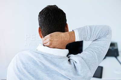 Buy stock photo Rearview shot of a businessman suffering with neck pain while working in an office