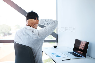 Buy stock photo Rearview shot of a businessman suffering with neck pain while working in an office