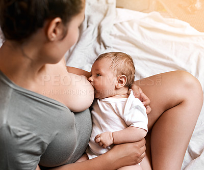 Buy stock photo High angle shot of a young mother breastfeeding her newborn baby at home