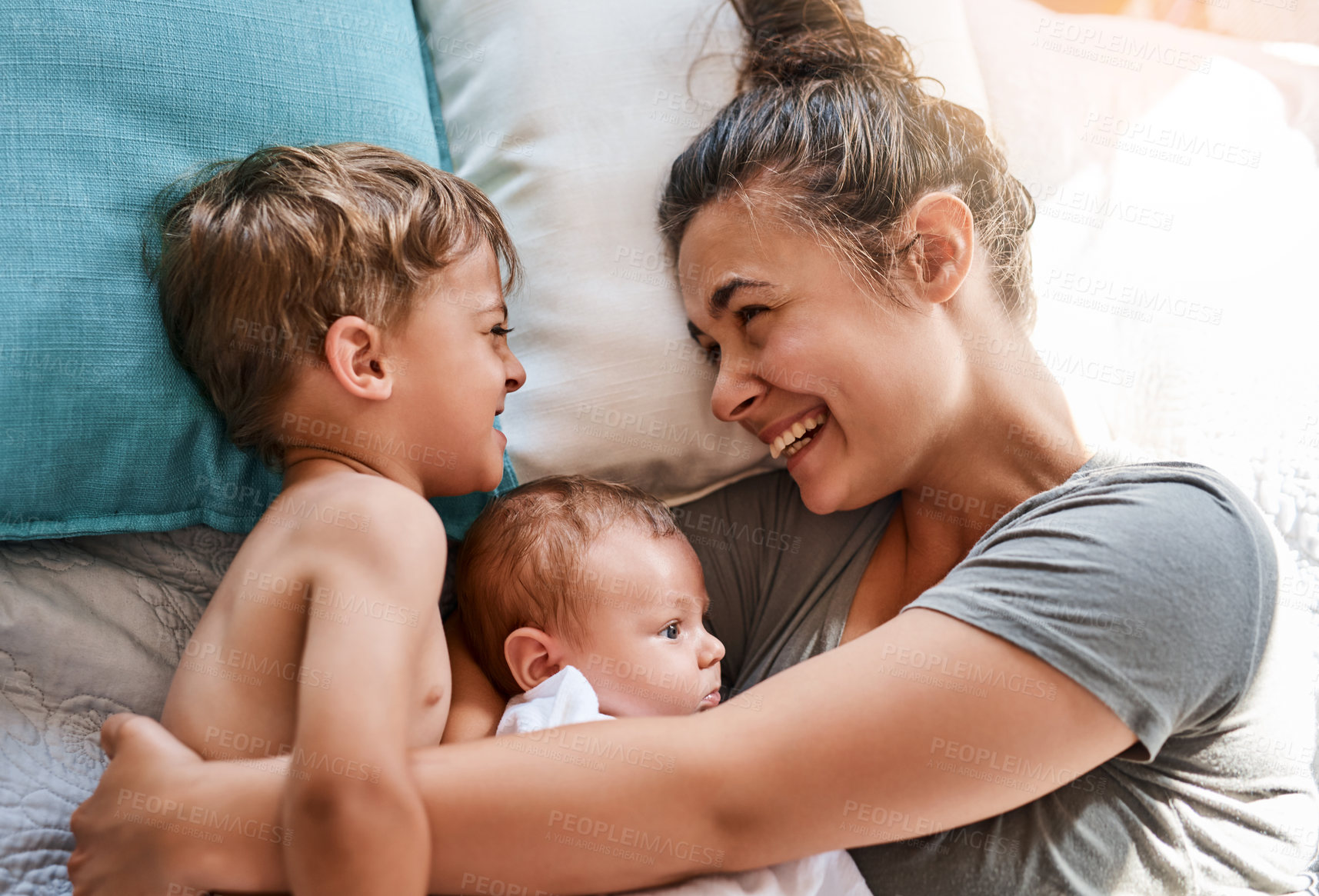 Buy stock photo Shot of a young woman bonding with her two sons at home