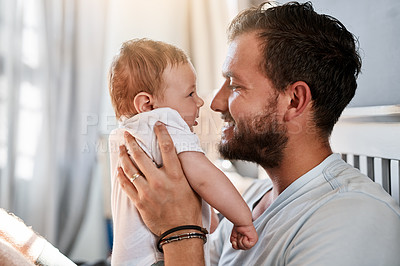 Buy stock photo Shot of a young man bonding with his baby boy at home