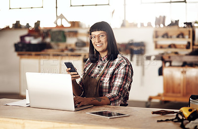 Buy stock photo Cropped portrait of an attractive young woman working on her laptop while sitting in her creative workshop