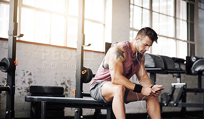 Buy stock photo Cropped shot of a handsome young man taking a break during his workout at the gym