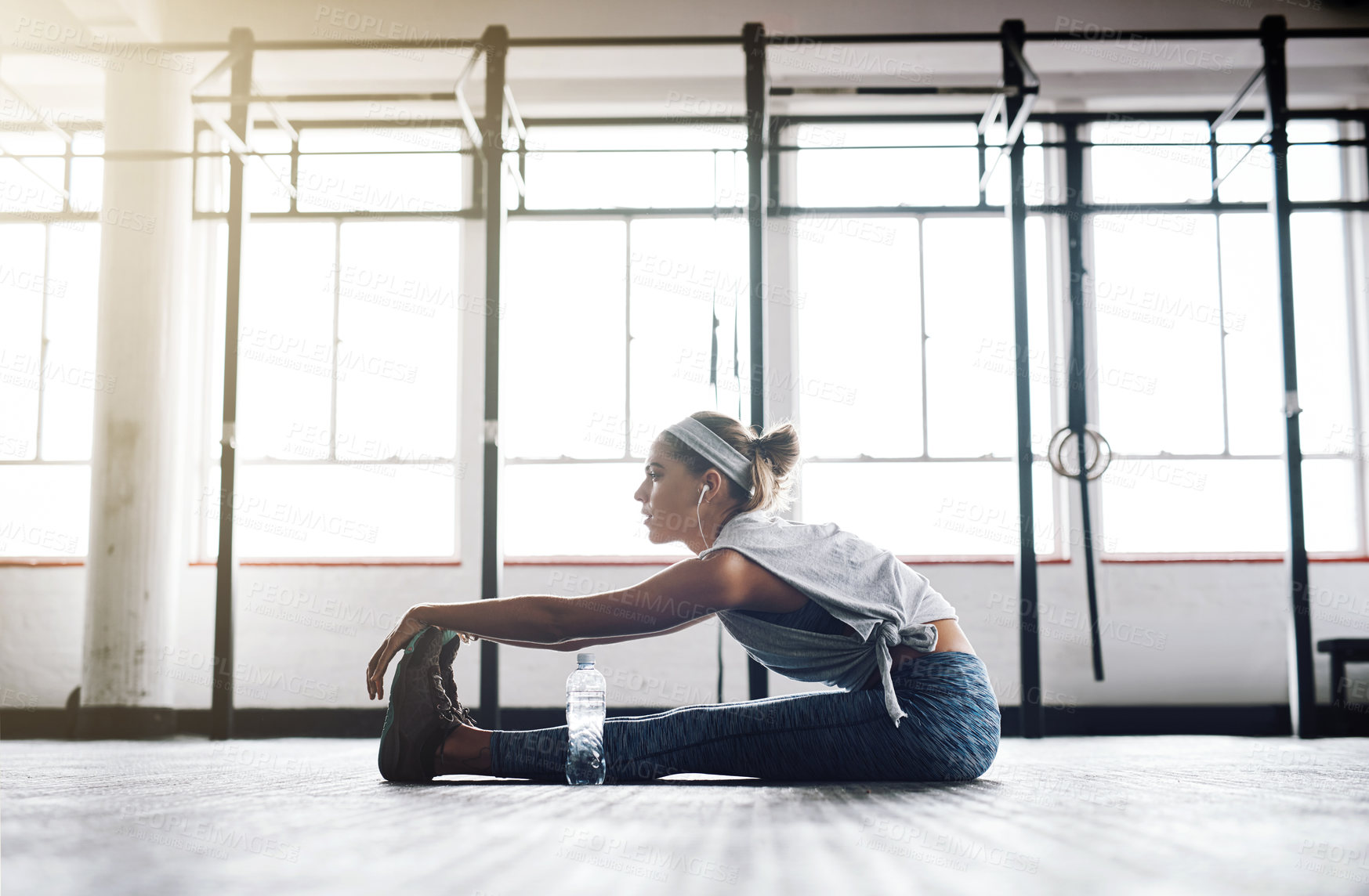 Buy stock photo Exercise, music and stretching with woman on floor of gym for health, improvement or wellness. Fitness, legs and warm up for workout with athlete getting ready for physical improvement or training