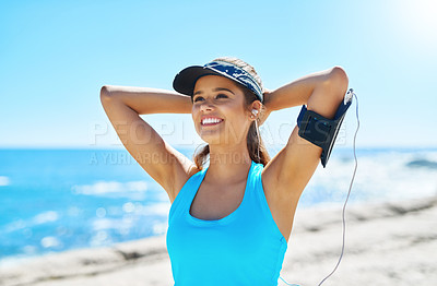 Buy stock photo Fitness, happy woman and stretching at beach with music, peace and warm up for exercise. Athlete girl, thinking and tech at seaside for streaming, motivational podcast and workout ready in Colombia