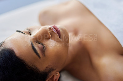 Buy stock photo Shot of an attractive young woman relaxing on a massage table at a spa