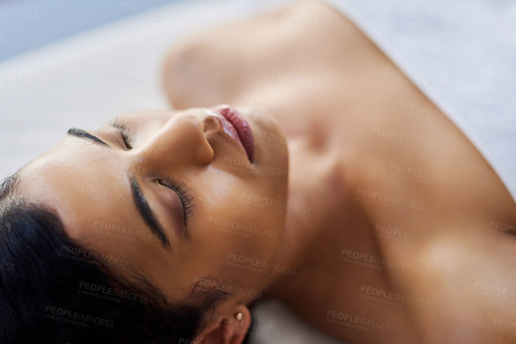 Buy stock photo Shot of an attractive young woman relaxing on a massage table at a spa