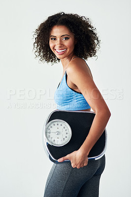 Buy stock photo Studio shot of an athletic young woman holding a scale against a grey background
