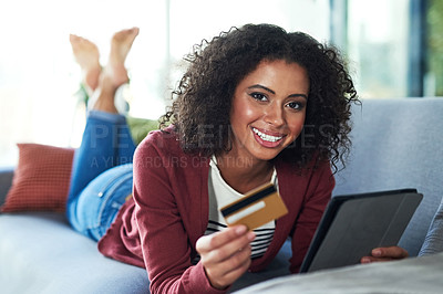 Buy stock photo Portrait of a young woman using a digital tablet and credit card on the sofa at home
