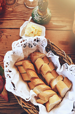 Buy stock photo Bread, food and butter on a table for lunch, breakfast or dinner with lens flare for carbs and healthy eating background. Fresh baked french baguette for nutrition in a basket for a bakery mock up