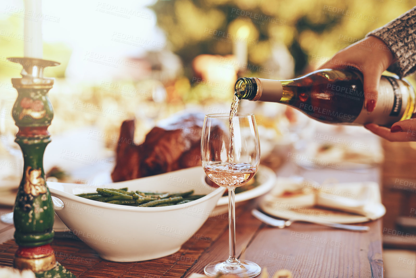 Buy stock photo Champagne, dinner and hands with a woman pouring a drinking during a Christmas party outdoor. Tradition, celebration and alcohol with a feast on a wooden table for a social gathering outside