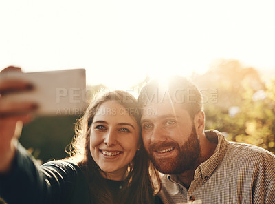Buy stock photo Selfie, smile and couple in nature with a phone for social media, memory and happiness. Flare, happy and young man and woman with a photo on a mobile while on a date in a park for love in marriage