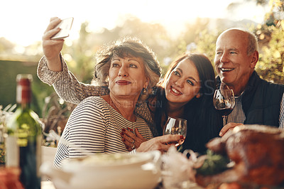 Buy stock photo Family, phone selfie and happy thanksgiving, lunch and happy with wine, glass and social media photo in home. Senior mother, father and daughter smile, love and together for picture, alcohol and care