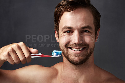 Buy stock photo Portrait, toothbrush and toothpaste with man in studio isolated on blue background for dental care. Brushing teeth, face and oral hygiene with person in bathroom, cleaning mouth for protection