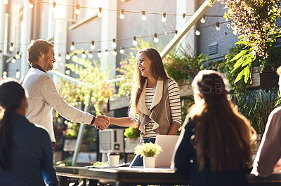 Buy stock photo Cropped shot of colleagues shaking hands during a meeting at an outdoor cafe