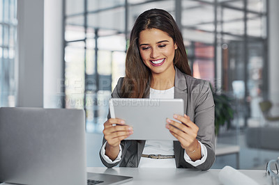 Buy stock photo Cropped shot of a young businesswoman working on a digital tablet in an office