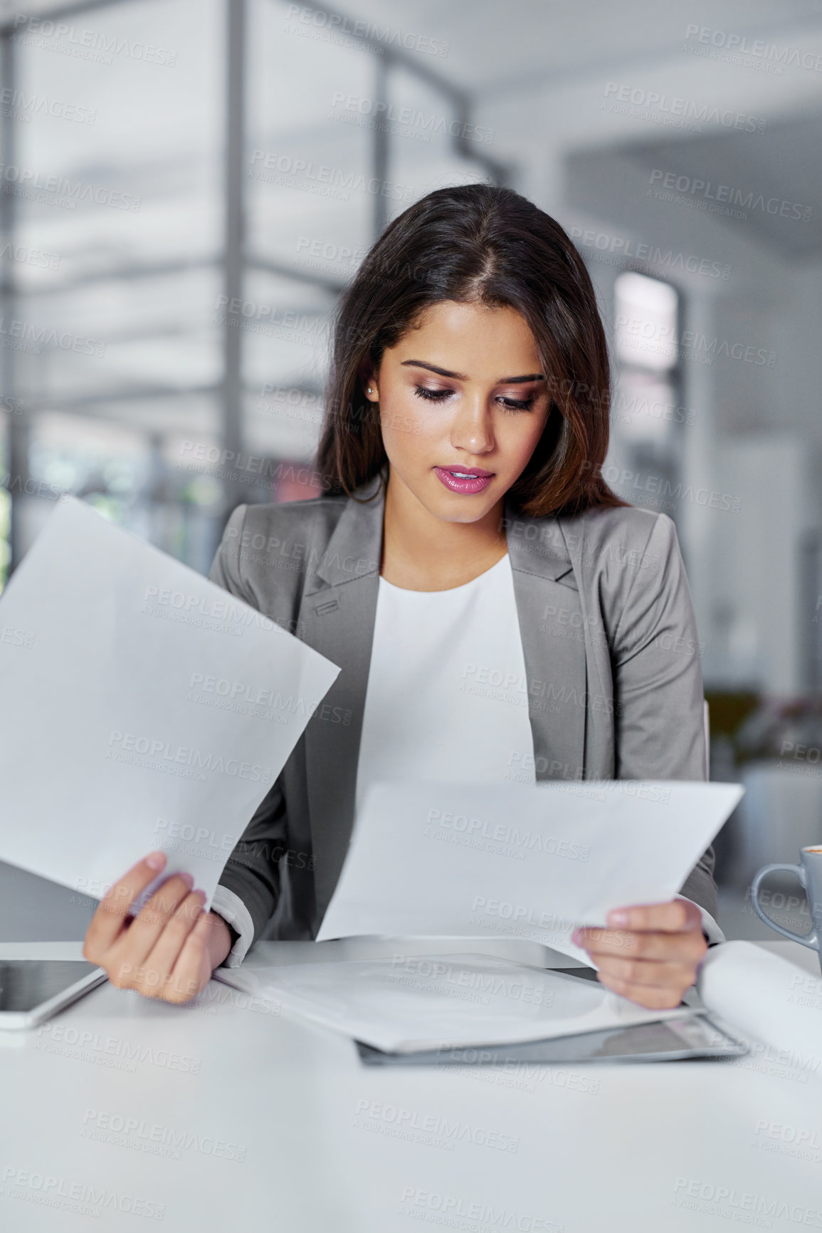 Buy stock photo Cropped shot of a young businesswoman looking through some paperwork in an office