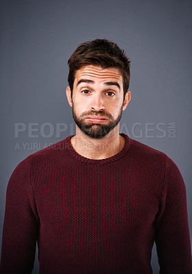 Buy stock photo Studio shot of a handsome young man looking sad against a gray background