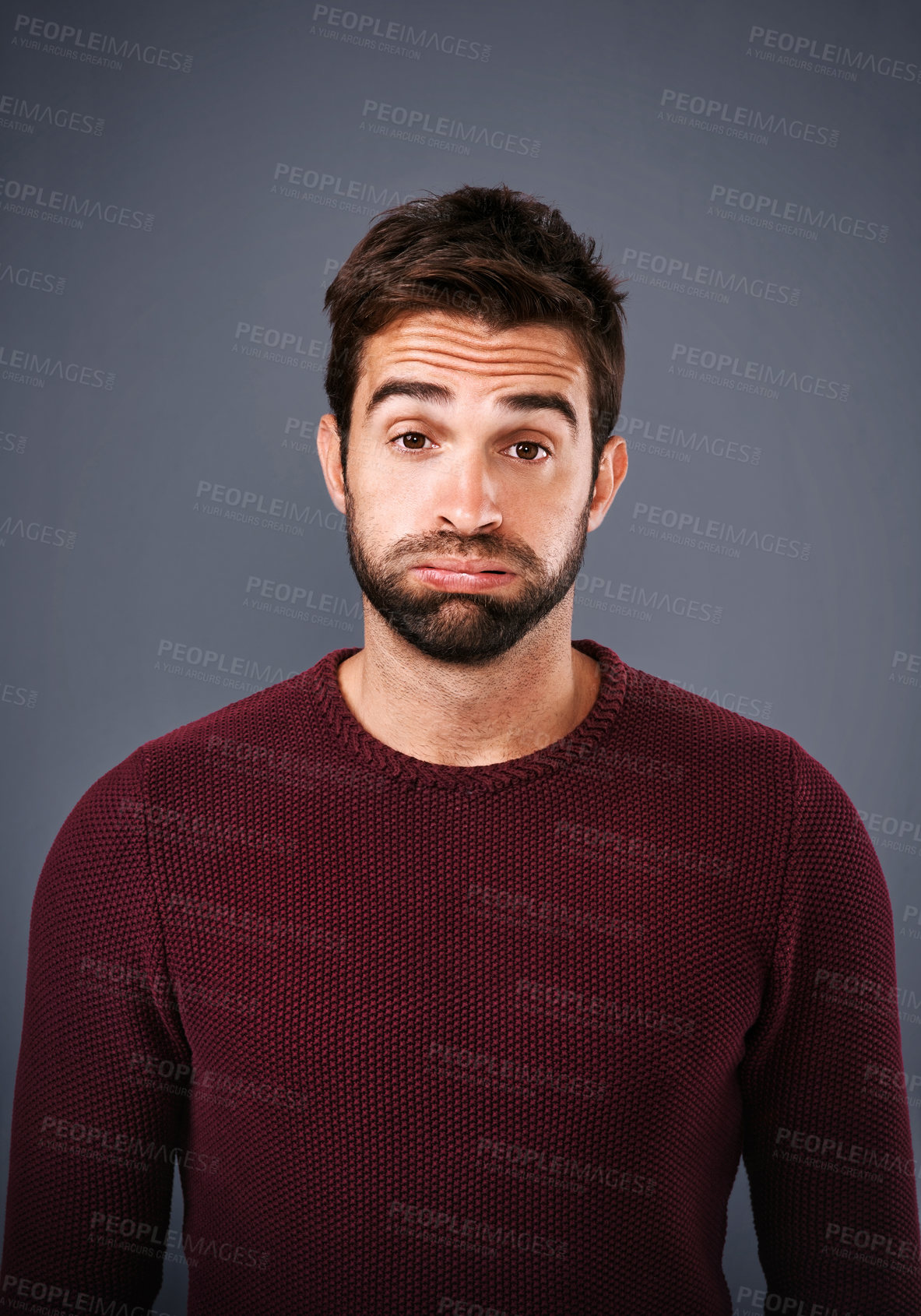 Buy stock photo Studio shot of a handsome young man looking sad against a gray background
