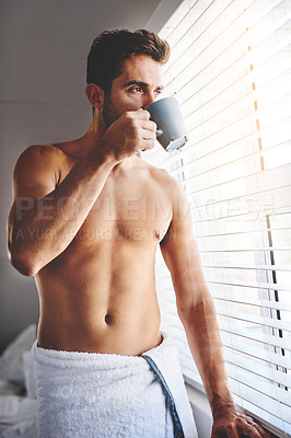Buy stock photo Cropped shot of a handsome young man drinking coffee while standing in a towel in his bedroom at home