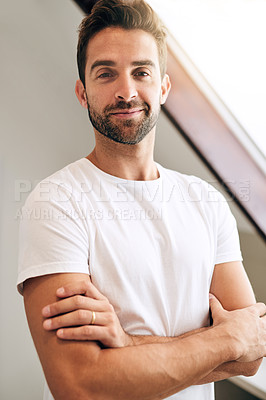 Buy stock photo Cropped shot of a handsome young man standing with his arms crossed in his bedroom at home