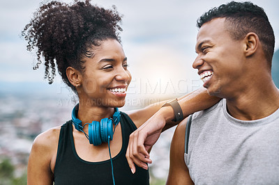 Buy stock photo Shot of a sporty young couple taking a break while exercising outdoors