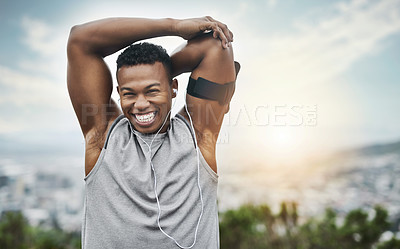 Buy stock photo Portrait of a sporty young man stretching his arms while exercising outdoors
