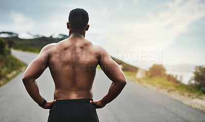 Buy stock photo Rearview shot of an unrecognizable young sportsman standing with his hands on his hips outside