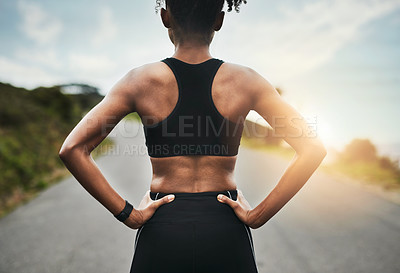 Buy stock photo Rearview shot of an unrecognizable young sportswoman standing with her hands on her hips outside