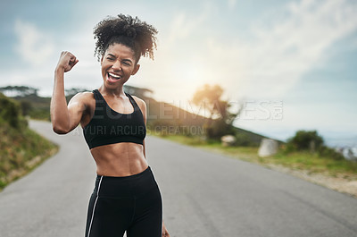 Buy stock photo Cropped shot of an attractive young sportswoman flexing her bicep outside