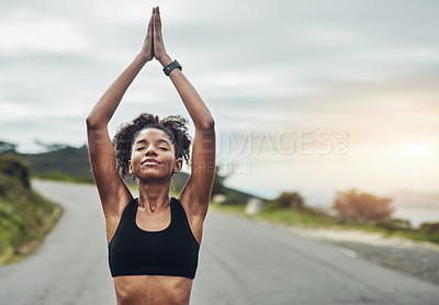 Buy stock photo Cropped shot of an attractive young sportswoman meditating during her workout outdoors