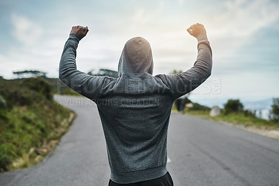 Buy stock photo Rearview shot of an unrecognizable young sportsman cheering in celebration outside