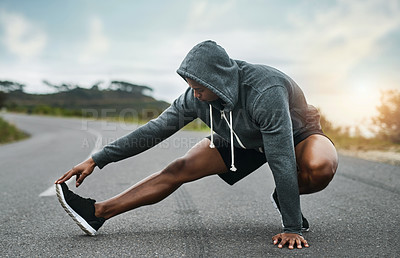 Buy stock photo Full length shot of a handsome young sportsman warming up for a workout outdoors