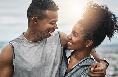 Buy stock photo Cropped shot of an affectionate and athletic young couple standing with their arms around one another outdoors