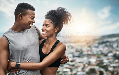 Buy stock photo Cropped shot of an affectionate and athletic young couple standing with their arms around one another outdoors