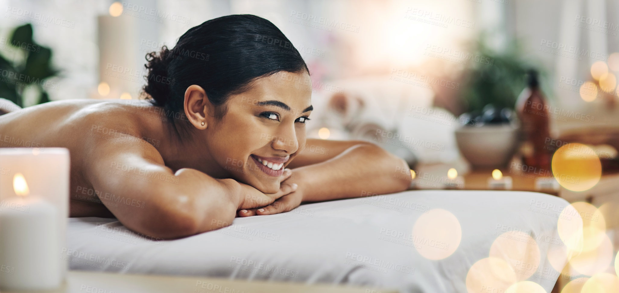 Buy stock photo Shot of a relaxed an cheerful young woman getting a massage indoors at a spa