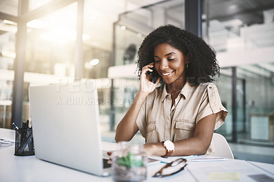 Buy stock photo Shot of a young businesswoman using a mobile phone and laptop at her desk in a modern office