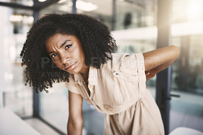 Buy stock photo Portrait of a young businesswoman experiencing back pain while working in a modern office