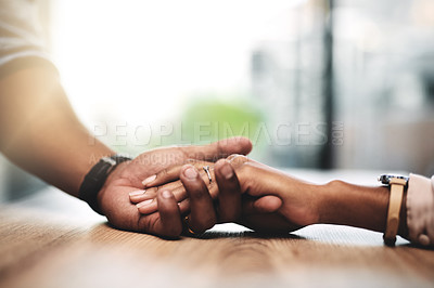 Buy stock photo Cropped shot of a man and woman holding hands at a table