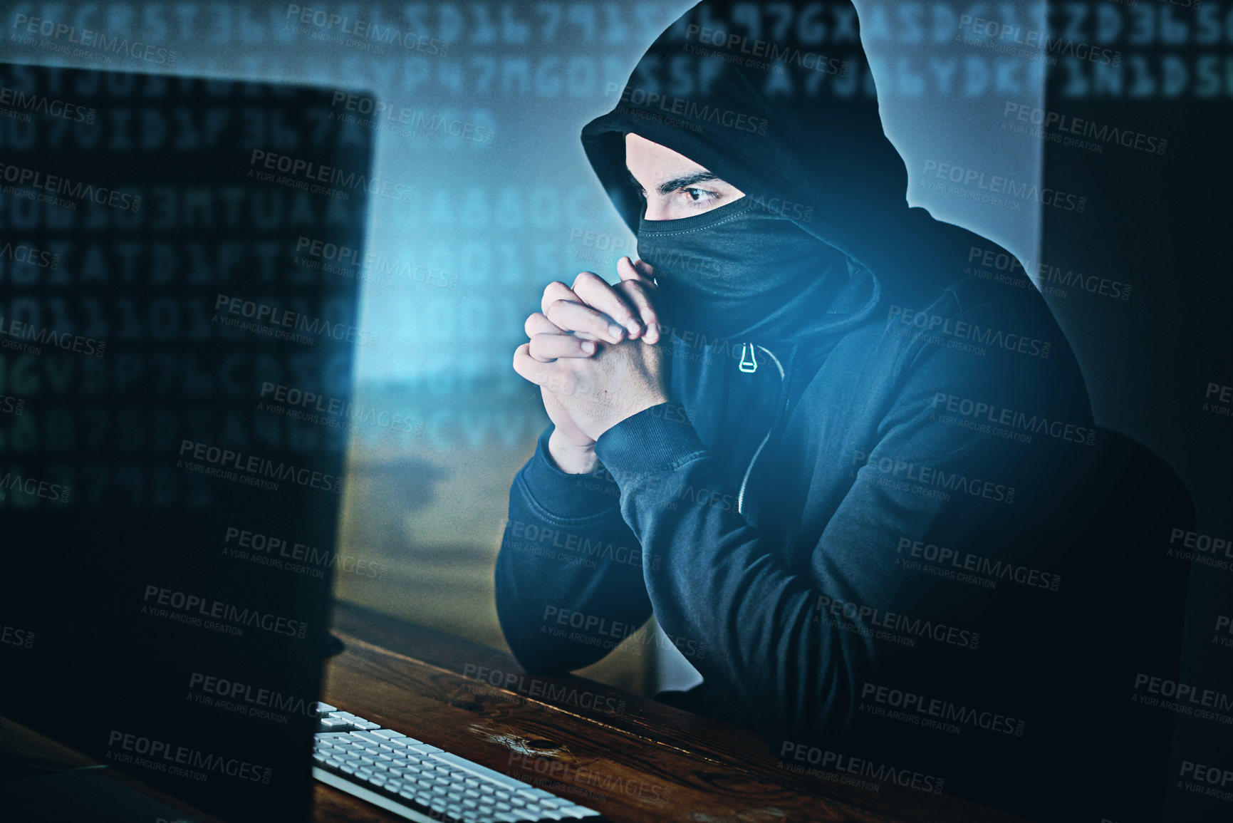 Buy stock photo Shot of a young hacker using a computer late at night