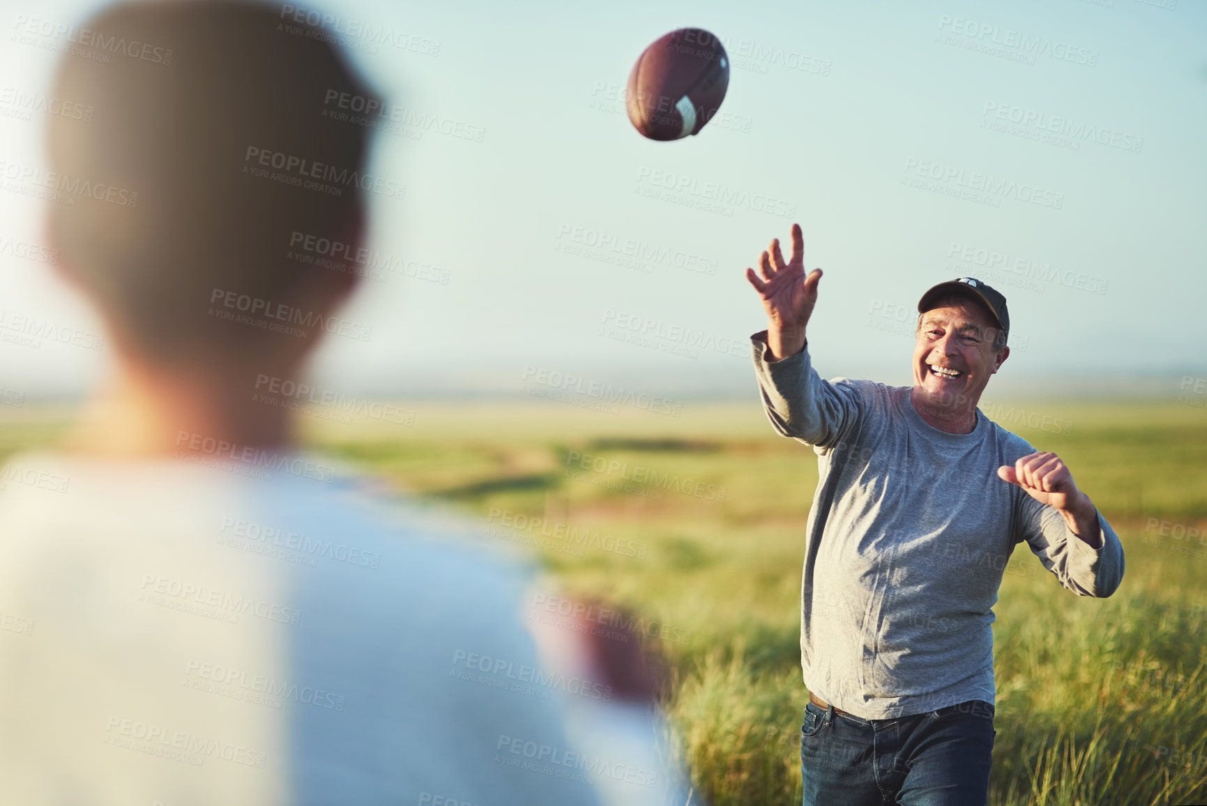 Buy stock photo Kid, man and throw with football on grass field for outdoor sports, teaching and child development. Happy, dad and smile with son in nature for practice, exercise and bonding together on fathers day