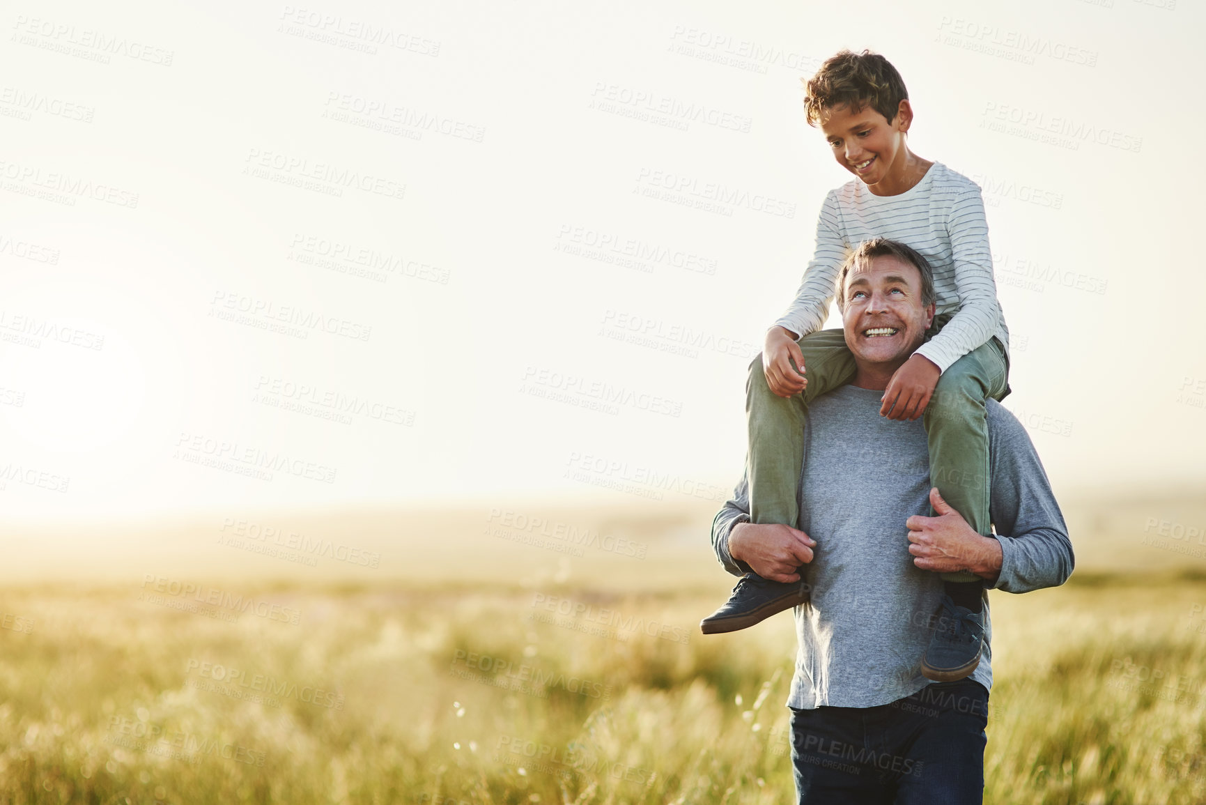 Buy stock photo Smile, father and piggyback of son in nature, love and outdoor of family in space, sunshine and grass. Countryside, dad and visit of Texas with boy for fresh air, man and bonding with child in farm