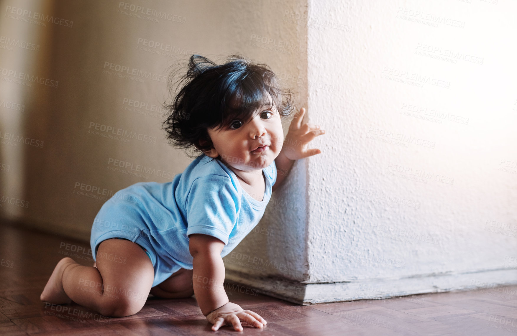 Buy stock photo Shot of a little baby boy playing and hiding around a corner at home during the day