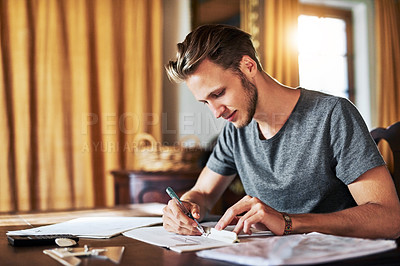 Buy stock photo Cropped shot of a young man working on a project at home